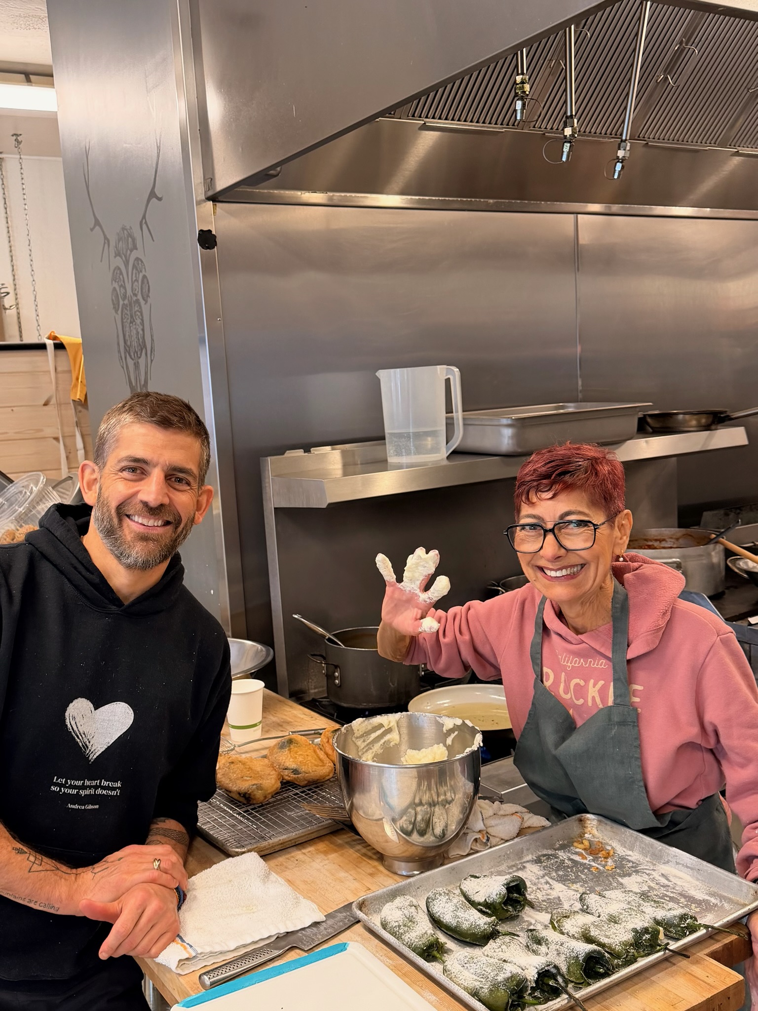 Two smiling cooks making chiles rellenos in the Truckee Food Shop kitchen